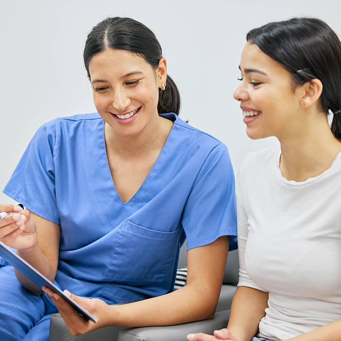 Dental team member showing a clipboard to a patient