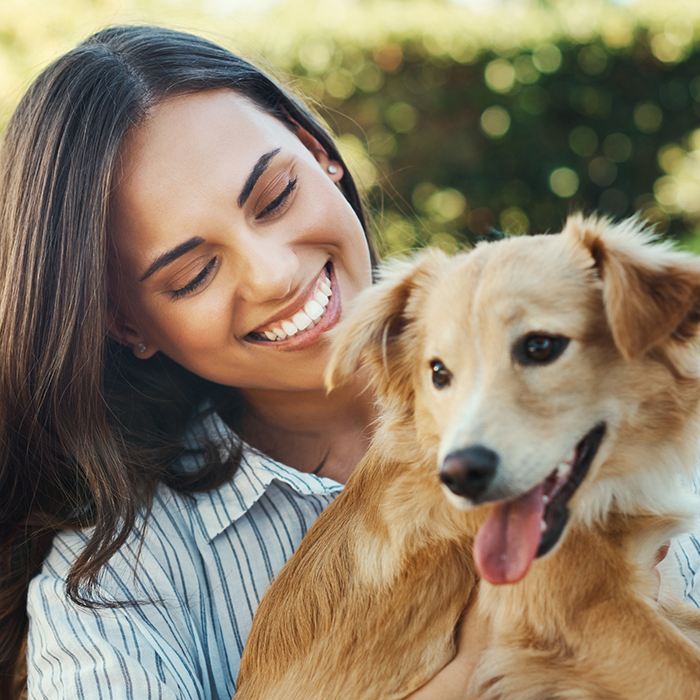 Woman smiling with a dog with fluffy golden fur