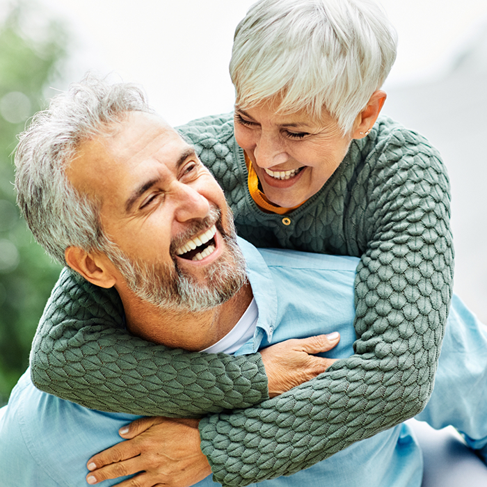 Senior couple laughing and hugging outdoors