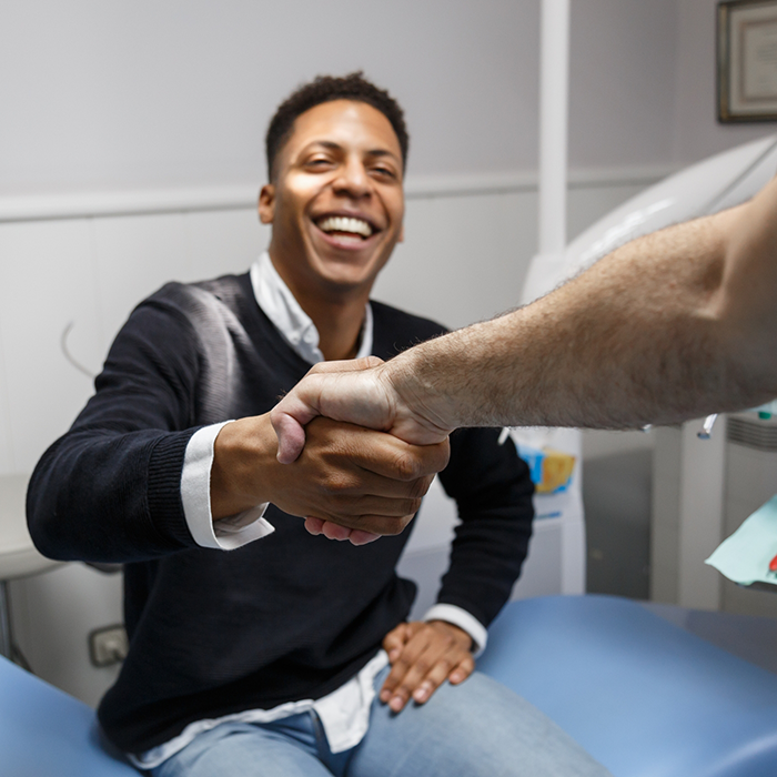 Smiling man shaking hands with his dentist