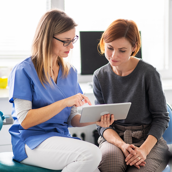 Dental team member showing a tablet to a patient