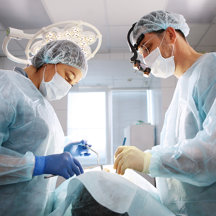 Dentist and assistant performing gum disease treatment on a patient