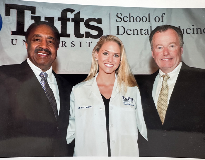 Doctor Lundgren with two men in suits at Tufts University School of Dental Medicine