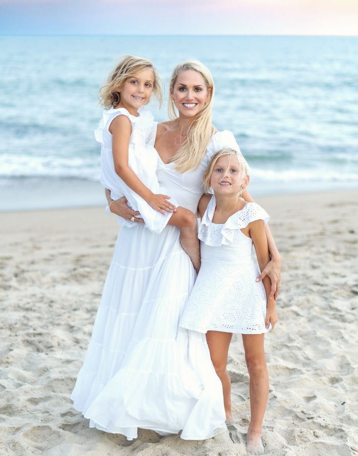 Doctor Lundgren with her two young daughters on the beach in white dresses