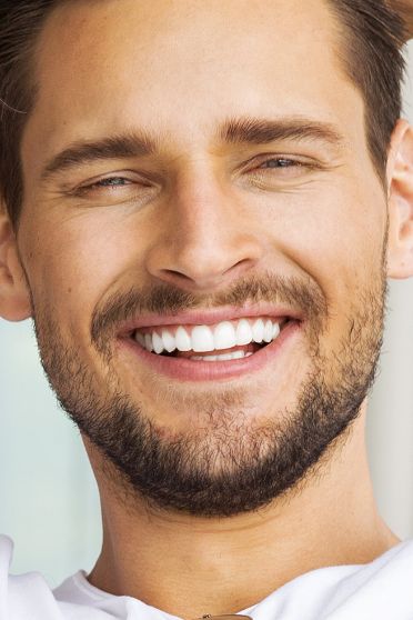 Young man with short facial hair smiling