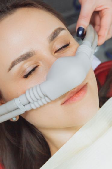 Dental patient with a nitrous oxide mask over her nose