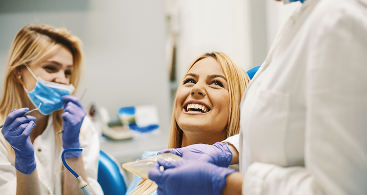 Woman grinning at her dentist during a preventive dentistry checkup in Wilmington