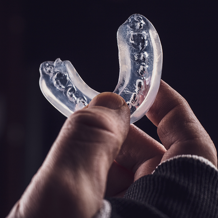 Hand holding a clear mouthguard