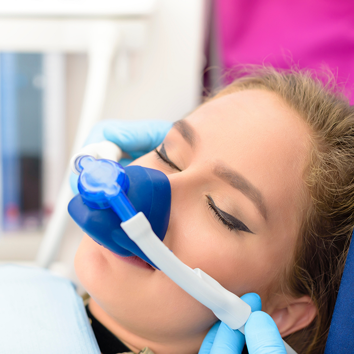 Dental patient with a nitrous oxide sedation mask over her nose